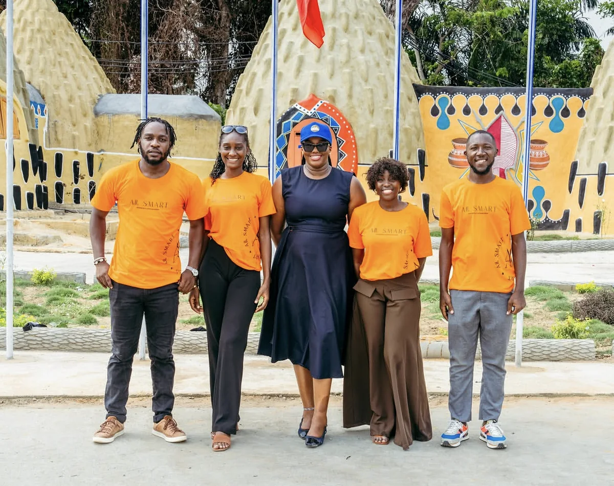 La team AllSmart en t-shirts orange, devant des cases peintes